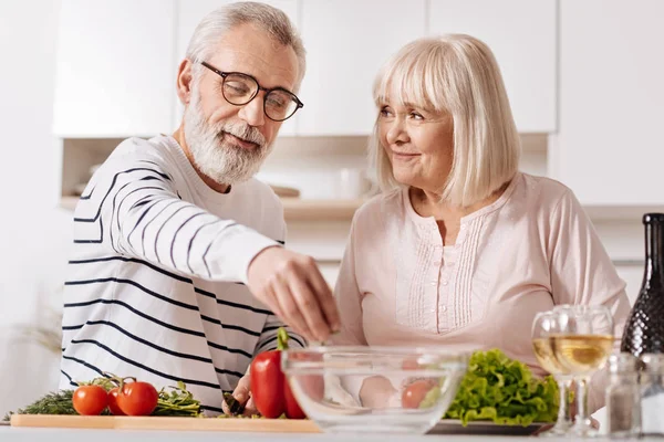 Оптимистичная пожилая пара готовит вместе — стоковое фото