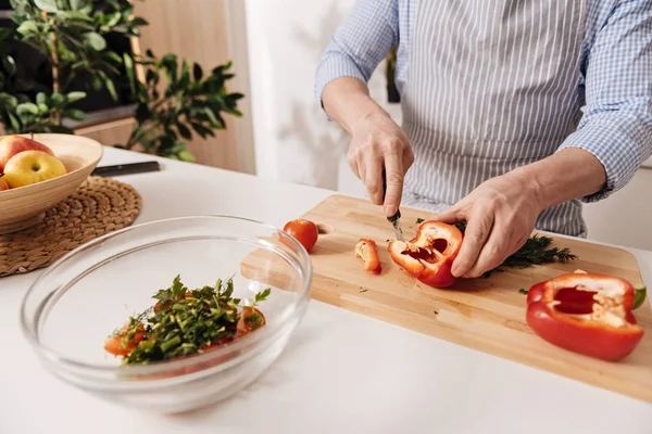 Profesjonell kokk skjærer pepper til middag – stockfoto