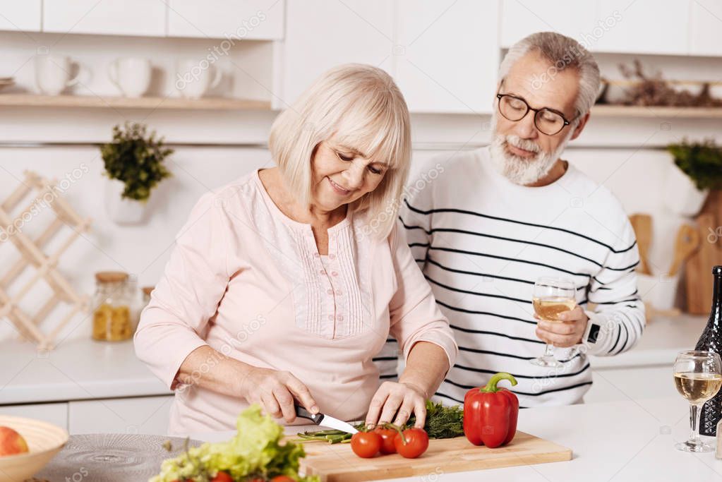 Cheerful aged couple cooking in the kitchen