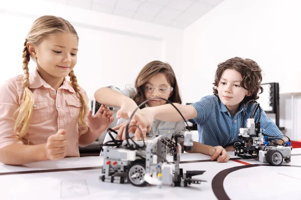 Оптимистичные дети, работающие над технологическим проектом — стоковое фото