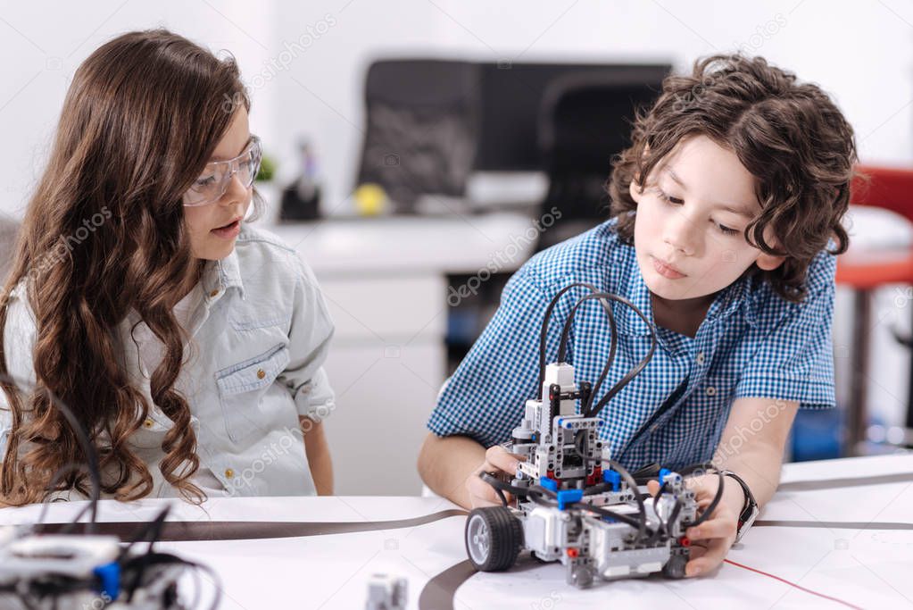 Inquisitive pupils exploring robot 