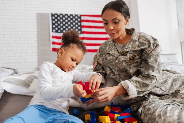 Woman helping her daughter building a castle — Stock Photo, Image
