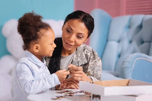 Mamma att ge sitt barn en pusselbit — Stockfoto