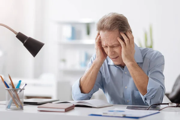 Gray-haired mannelijke persoon die hoofdpijn — Stockfoto