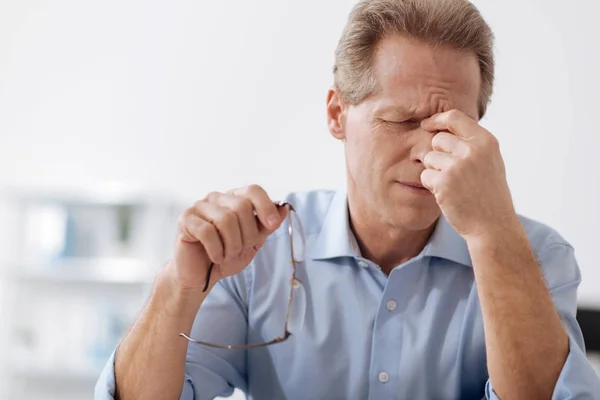 Disappointed male person touching his bridge of nose — Stock Photo, Image