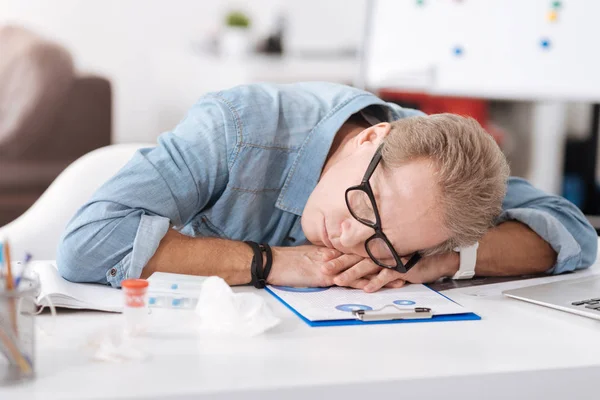 Müder Mann legt den Kopf auf die Hände — Stockfoto