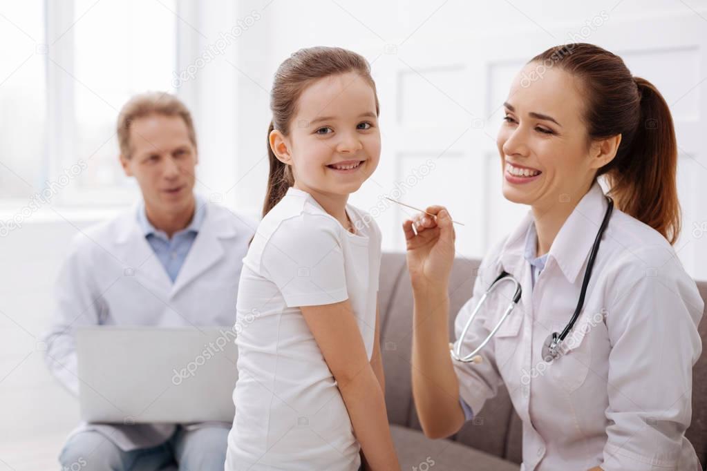 Joyful little girl enjoying her medical checkup