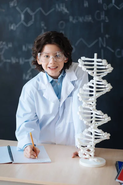 Criança tomando notas no laboratório — Fotografia de Stock