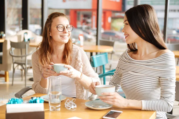 Две девушки разговаривают в кафетерии — стоковое фото