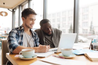 İki öğrenci dizüstü bilgisayarda birlikte çalışma