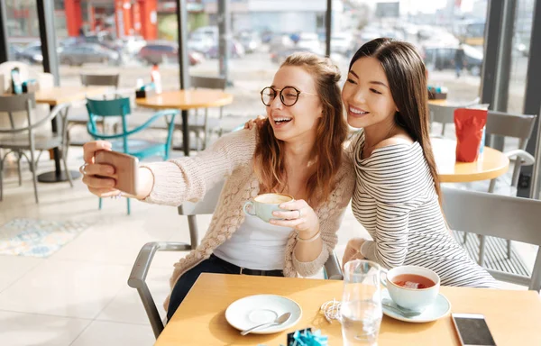 Two girlfriends doing selfie at cafe — Stock Photo, Image