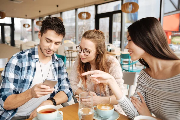 Vrienden met behulp van smartphones samen — Stockfoto