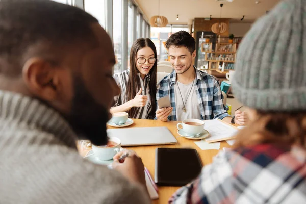 Ungdomar använder smartphones i caféet — Stockfoto