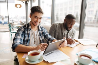 Neşeli öğrenciler kafede oturan