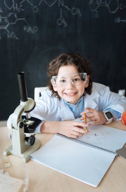 Küçük scintist okulda Mikrobiyoloji projede çalışan gülümseyen