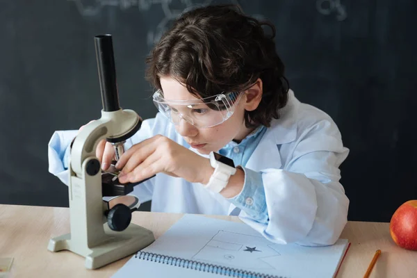 Pequeño científico persistente que participa en el experimento de microbiología en la escuela —  Fotos de Stock