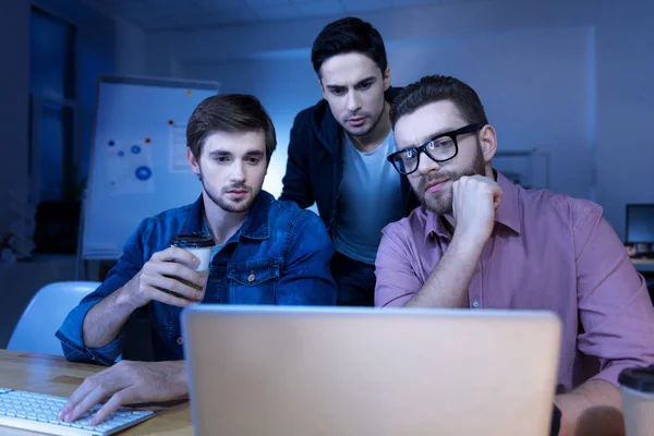 Красивые умные мужчины смотрят на экран ноутбука — стоковое фото