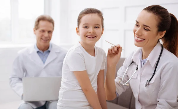 Chica divirtiéndose mientras visita al médico — Foto de Stock