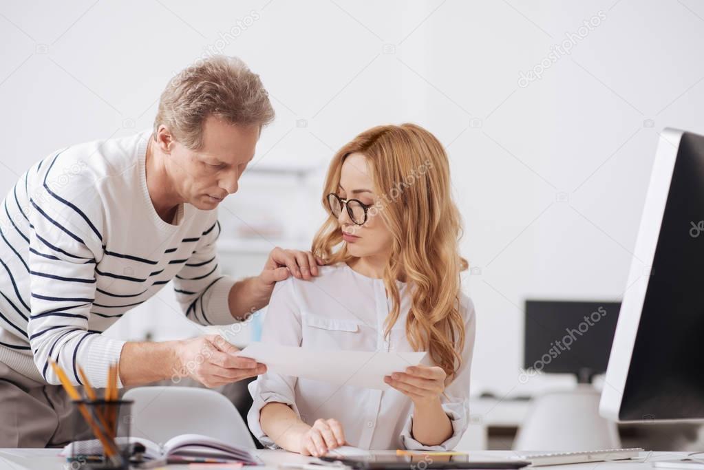 Busy aging manager touching young colleague in the office