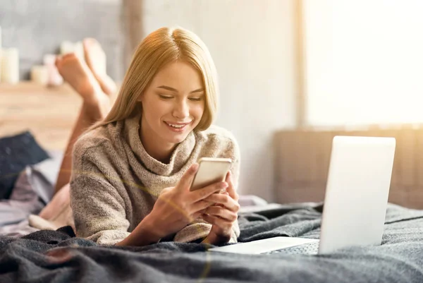 Sorridente giovane donna che utilizza le tecnologie a casa — Foto Stock