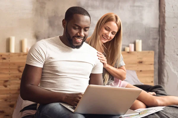 Alegre pareja internacional disfrutando de compras en línea en casa — Foto de Stock