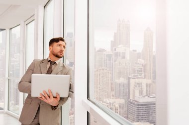 Ciddi businesssman ofis pencere eğilerek