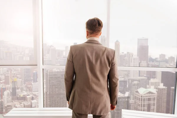 Бизнесмен, стоящий у окна — стоковое фото