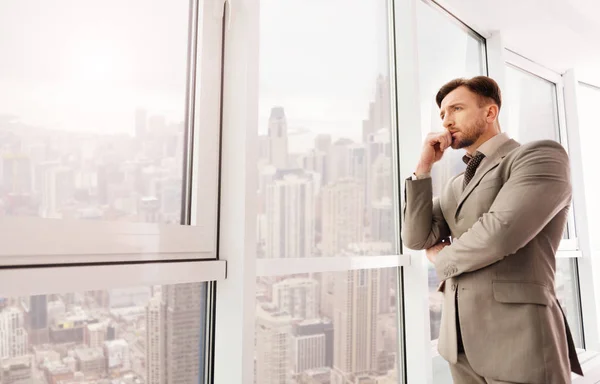 Geschäftsmann blickt von seinem Büro auf die Stadt — Stockfoto