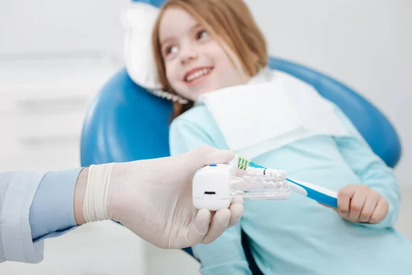 Encantador dentista pediátrico enseñando a su pequeño paciente — Foto de Stock