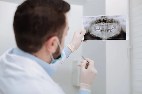 Konzentrierte professionelle Zahnarzt untersucht Patienten Röntgen — Stockfoto