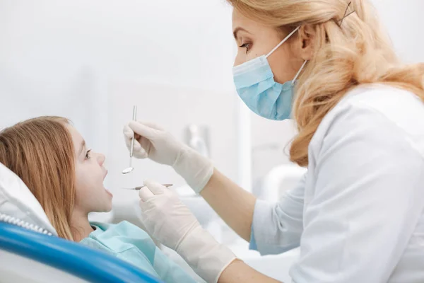 Adorável bom dentista fazendo uma verificação regular — Fotografia de Stock