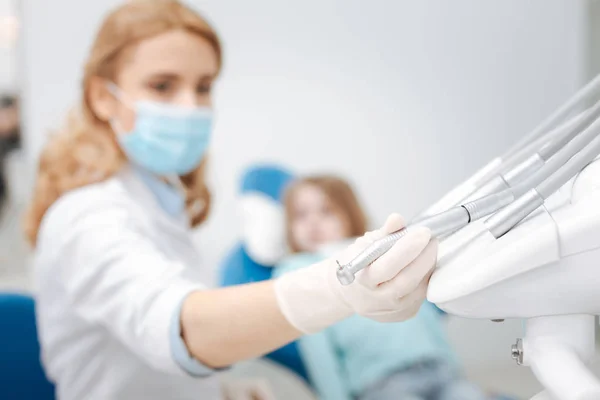 Präzise kompetente Zahnärztin nimmt Zahnbohrer — Stockfoto