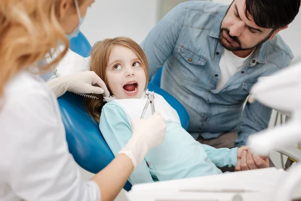 Obedient good child having her baby tooth removed — Stock Photo, Image