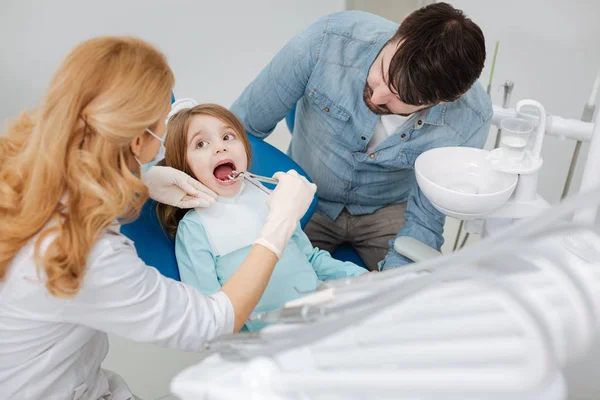 Dentista pediátrico profissional sendo muito atencioso — Fotografia de Stock