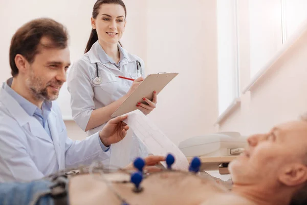 Two colleagues having a pleasant conversation with their patient — Stock Photo, Image