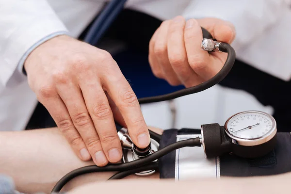 Competent attentive doctor being careful with measurements Stock Picture