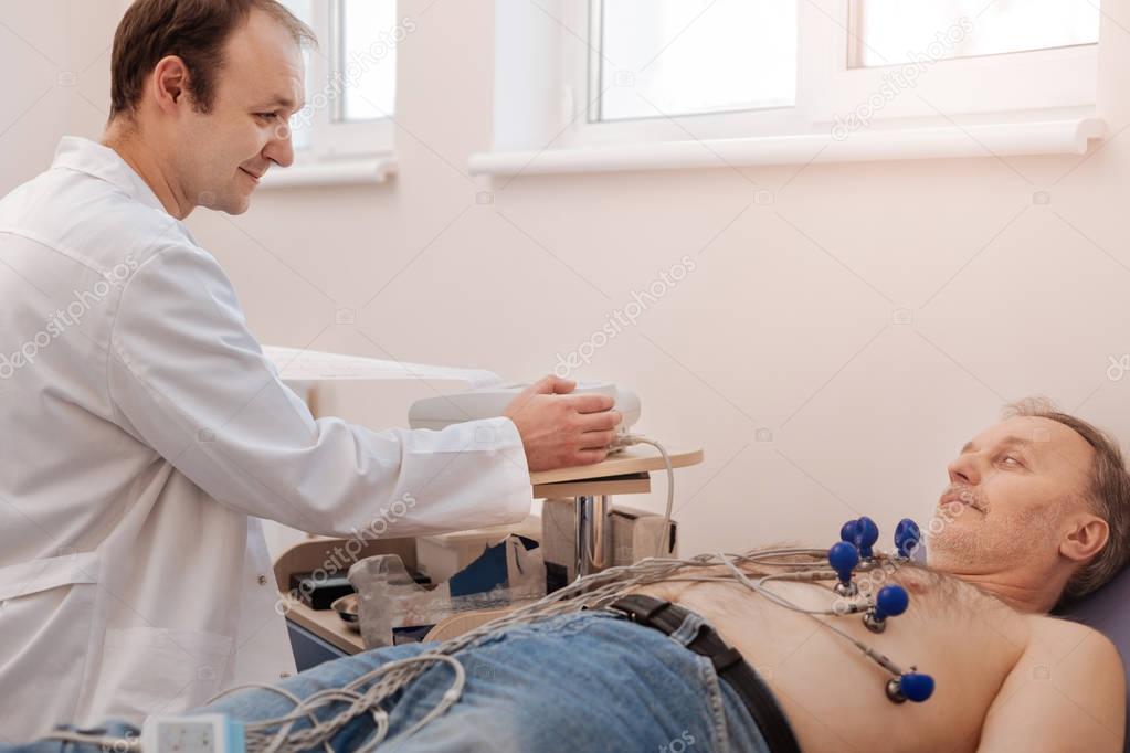 Pleasant cardiologist making sure his patient feeling comfortable