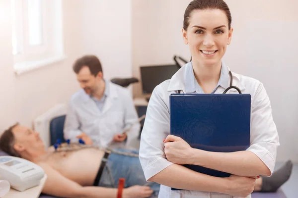 Jovem cardiologista proeminente feliz fazendo seu trabalho — Fotografia de Stock