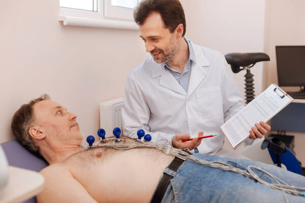 Delighted cardiologist telling the patient about his progress