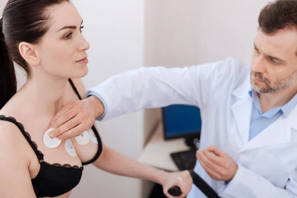 Trabalhador médico cuidadoso aplicando sensores no peito das mulheres — Fotografia de Stock
