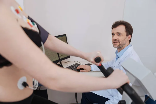 Simpático excelente cardiólogo teniendo una conversación con su paciente — Foto de Stock