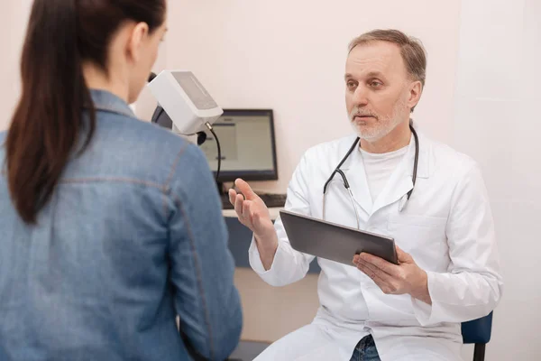 Attentive competent doctor asking the patient about her problem — Stock Photo, Image