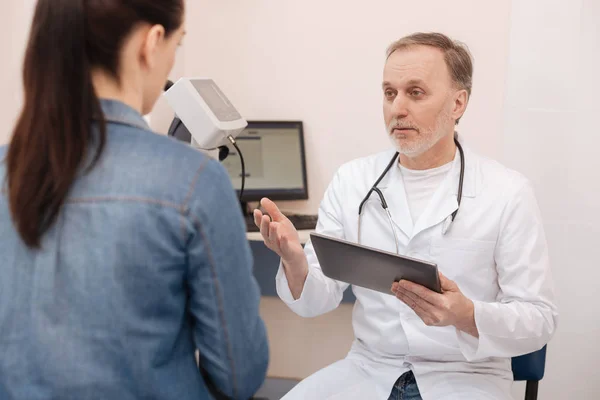 Aufmerksamer, kompetenter Arzt fragt die Patientin nach ihrem Problem — Stockfoto