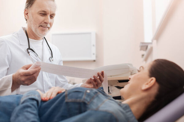 Optimistic cardiologist having some good news for young lady