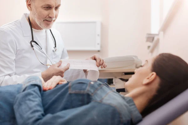 Lively excellent doctor showing the patient her results — Stock Photo, Image