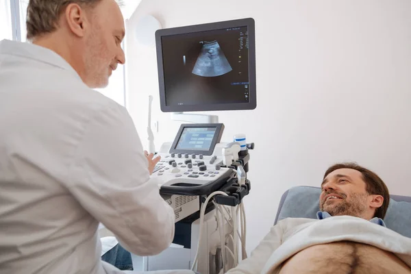 Encantador médico calificado que cuenta los resultados de los pacientes ultrasonido —  Fotos de Stock