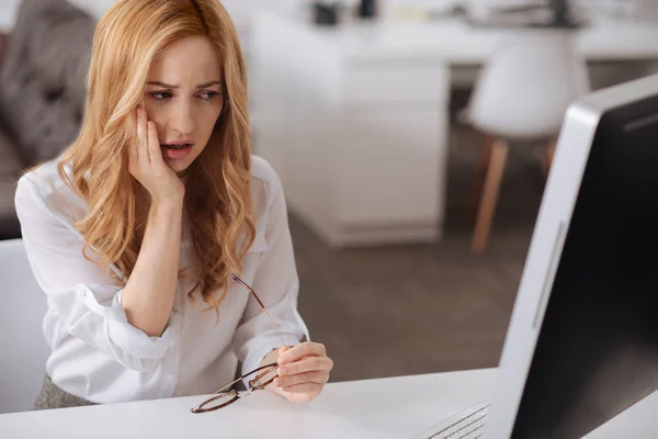 Épuisé jeune femme toucher sa joue douloureuse dans le bureau — Photo