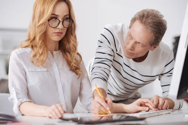 Ernstige baas schriftelijke berisping aan jonge secretaris in het kantoor — Stockfoto