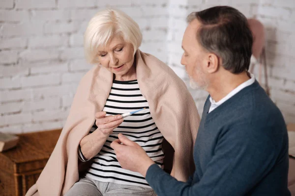 Senior woman checking temperature near her husband — Stock Photo, Image