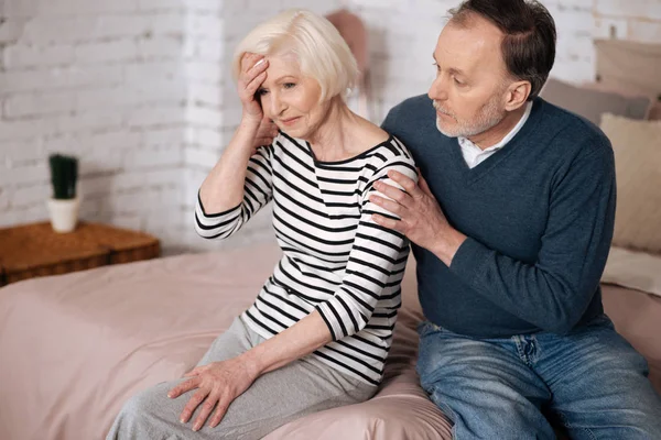 Man ger tröst till hustrun senior med huvudvärk — Stockfoto